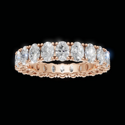 A rose gold eternity ring featuring a row of oval-cut clear diamonds set in a polished band, shown against a solid black background.