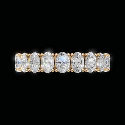 A yellow gold eternity ring featuring a row of marquise-cut clear diamonds set in a five-stone pattern, shown against a solid black background.
